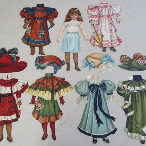 May include: A set of paper dolls with various outfits and accessories. The dolls are dressed in a variety of styles, including a red dress with a blue sash, a blue dress with a white sash, and a green dress with a white collar. The dolls also have a variety of hats and shoes.
