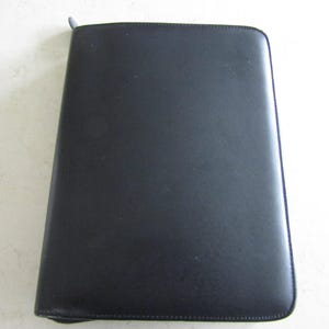 May include: A black leather zippered binder or portfolio.