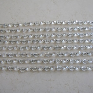 May include: Eight strands of clear crystal beads strung on silver wire. Each strand is approximately 12 inches long.