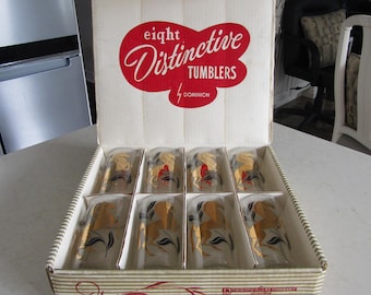 May include: A box of eight gold-rimmed glass tumblers with a horse design. The box is white with red and gold lettering that reads "eight Distinctive Tumblers by Dominion".
