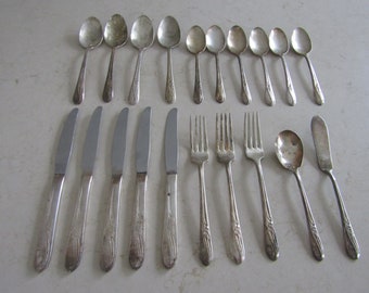 May include: A set of vintage silverware, including spoons, forks, and knives. The silverware is made of silver and has a floral design.