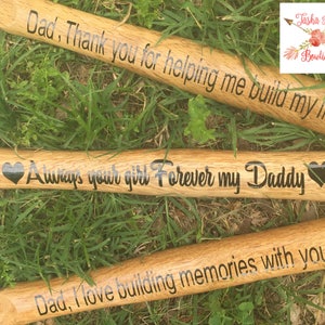 May include: Three wooden hammers with black engraved messages. The first hammer reads "Dad, Thank you for helping me build my life!" The second hammer reads "Always your girl Forever my Daddy" with a heart on each side of the message. The third hammer reads "Dad, I love building memories with you!"