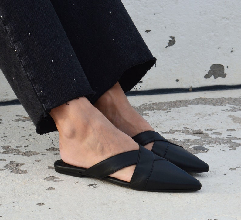 K&ouml;nnte beinhalten: Schwarze Leder-Sandalen mit spitzem Zeh und gekreuztem Riemen.