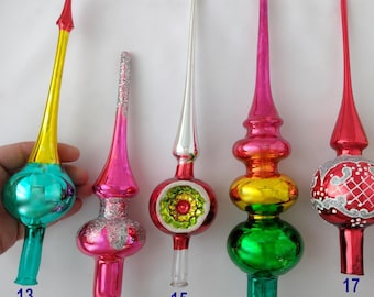 Puede incluir: Seis puntas de árbol de Navidad de vidrio de estilo vintage numeradas del 13 al 18. Estos adornos presentan puntas alargadas y bases bulbosas en varios colores, incluyendo turquesa, rosa, plata, rojo, verde, amarillo, naranja y morado.