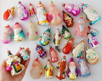 May include: A collection of vintage glass Christmas ornaments in various colors and designs, including Santa Claus, angels, and other holiday figures. The ornaments are all hand-blown and have a unique, rustic charm.