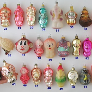 Puede incluir: Una colección de 52 adornos navideños vintage de vidrio con varios diseños de animales, incluyendo monos, elefantes, leones y tortugas. Los adornos están todos pintados a mano y tienen una variedad de colores, incluyendo rosa, azul, verde, dorado y rojo.