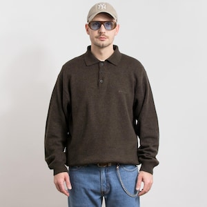 Peut inclure: Un polo marron à manches longues avec une patte de boutonnage à trois boutons. Le polo est porté avec un jean bleu, une ceinture marron et une chaîne argentée. Une casquette de baseball beige et des lunettes de soleil complètent le look. Le polo a un petit logo sur la poitrine.