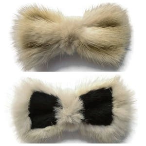Puede incluir: Dos accesorios para el cabello con forma de lazo esponjoso. El lazo superior es de color marrón claro liso. El lazo inferior tiene un centro negro con un borde blanco. Ambos lazos están hechos de un material suave y peludo.