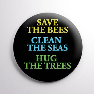 May include: A black button with the text "Save the Bees, Clean the Seas, Hug the Trees" in yellow, blue, and green.