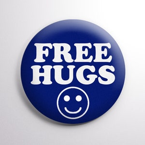 May include: A blue button with white text that reads "FREE HUGS" and a white smiley face.