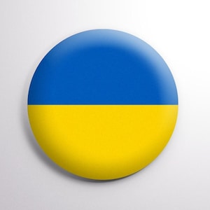 May include: A round button with the Ukrainian flag colors: blue on top and yellow on the bottom.