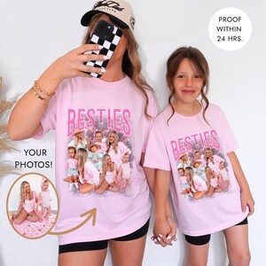 May include: Two pink t-shirts with the word "BESTIES" in pink script. The shirts feature a photo collage and the text "YOUR PHOTOS!" and "PROOF WITHIN 24 HRS." The person on the left is holding a phone with a black and white checkered case.