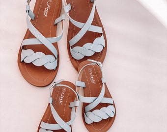 May include: Three pairs of blue sandals with brown soles. The sandals have criss-cross straps and a braided detail. The sandals are labeled "Forever Comfort" and "Link Comfort".