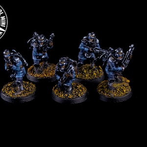May include: Five blue and grey painted miniature figures of soldiers wearing gas masks and holding weapons. The figures are standing on round black bases with yellow painted details.