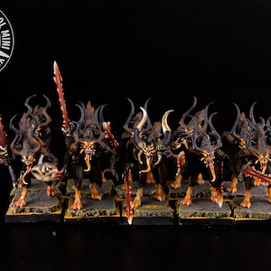 May include: A group of ten black and orange painted miniature figures with horns and swords. The figures are standing on small square bases.