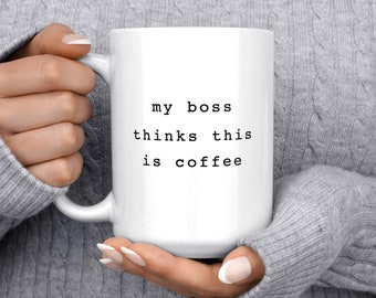 May include: White ceramic mug with black text that reads "my boss thinks this is coffee".