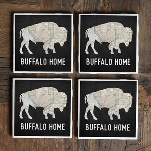 May include: Set of four black and white coasters with a map of Buffalo, New York, inside the silhouette of a buffalo. Each coaster has the text "Buffalo Home" printed on it.