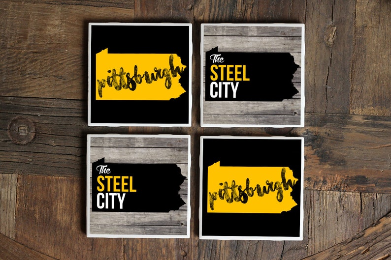 May include: Set of four black and yellow coasters featuring the outline of the state of Pennsylvania with the text "Pittsburgh" and "The Steel City".