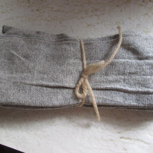 May include: A bundle of grey fabric tied with a natural twine string.