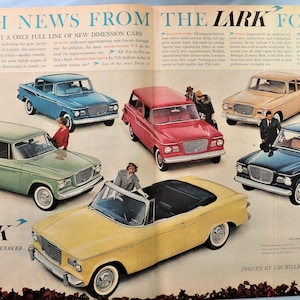 May include: An advertisement for the 1960 Studebaker Lark features a variety of car models in different colors, including blue, green, red, tan, and yellow. The ad includes text that reads "Fresh News From The Lark For 1960."