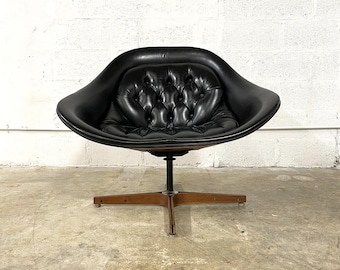 May include: A black leather swivel chair with a tufted back and a wooden base.