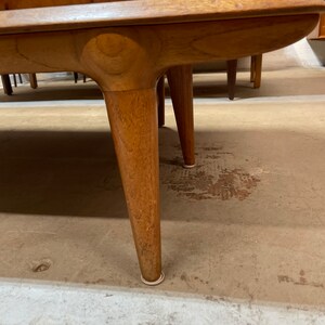 May include: Close-up of the bottom of a wooden cabinet with rounded legs and white protective pads on the bottom.