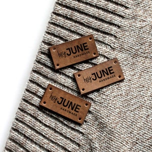 May include: Three brown leather labels with the text "hey JUNE HANDMADE" in black lettering.