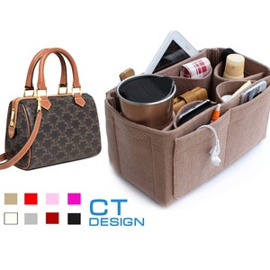 May include: A brown and beige patterned handbag with a brown leather handle and strap. The handbag is next to a beige felt organizer with multiple pockets and compartments. The organizer is filled with various items, including a phone, a tablet, a water bottle, and a pair of headphones.