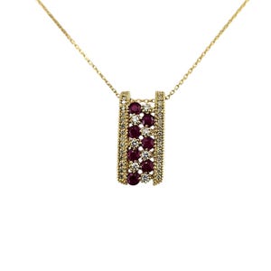 May include: A gold-colored necklace with a pendant featuring a rectangular design. The pendant is adorned with rows of red gemstones and smaller clear stones. The necklace hangs against a white background.