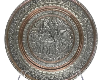 Plato decorativo de pared en tono plateado sobre cobre con jinete de camello