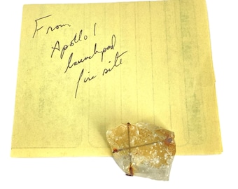 Muestra mineral etiquetada como "Del lugar del incendio de la plataforma de lanzamiento del Apolo 1" (vidrio coleccionable)