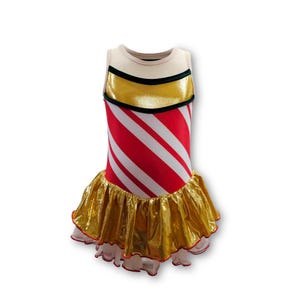 May include: A sleeveless dress with a cream-colored top, a gold metallic midsection, and a red and white striped bodice. The skirt is gold metallic with a ruffled hem. The dress is designed for dance or performance.