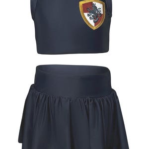 May include: A two-piece outfit in navy blue, featuring a sleeveless top with a white collar and a pleated skirt. The top has a crest with a red and gold design. The outfit is reminiscent of a school uniform.