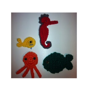May include: A set of five crocheted sea creatures, including a red seahorse, a yellow fish, a green fish, and an orange octopus. The sea creatures have black button eyes.