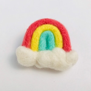 May include: A felt rainbow with red, yellow, and green stripes, sitting on a white felt cloud.