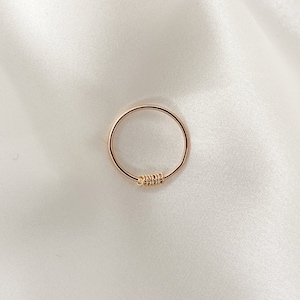 May include: A simple gold ring with a twisted detail.