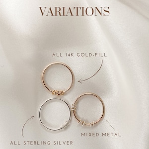 May include: Three variations of a simple ring with a twisted wire detail. The top ring is gold-filled, the middle ring is sterling silver, and the bottom ring is a mix of gold-filled and sterling silver. The text "ALL 14K GOLD-FILL", "ALL STERLING SILVER", and "MIXED METAL" are written below each ring.