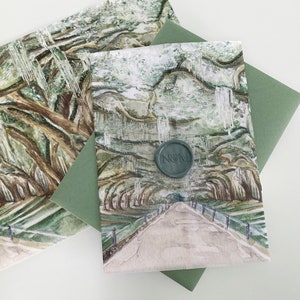 May include: A watercolor painting of a path lined with trees, with a green envelope and a wax seal with the initials "N&M" on it.