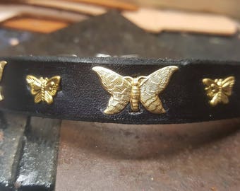 May include: Black leather dog collar with gold butterfly accents. The collar is decorated with five gold butterfly charms.