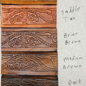 May include: Leather swatches in various shades of brown, from mahogany to antique black, with a decorative embossed pattern. The swatches are labeled with their corresponding color names: Mahogany, Tan, Saddle Tan, Briar Brown, Medium Brown, Dark Brown, and Antique Black.