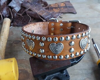 May include: A brown leather dog collar with silver studs and heart-shaped metal accents.