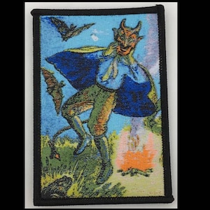 May include: A black and red embroidered patch featuring a devil with horns and a blue cape, standing on a fiery orange background with bats flying in the sky.