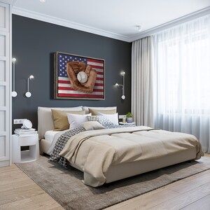 May include: A bedroom with a king-sized bed with a beige comforter and patterned pillows. A framed print of a baseball glove catching a ball on an American flag background hangs on the wall above the bed.