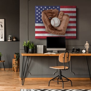 May include: A brown leather baseball glove with a white baseball inside, on a canvas print of the American flag.