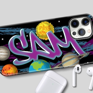 May include: A black phone case with a space theme. The case features a purple graffiti-style name "SAM" with planets and stars in the background.