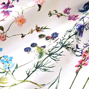 May include: White fabric with a floral print featuring blue, pink, purple, and green flowers. The flowers are arranged in a random pattern and are surrounded by green leaves.