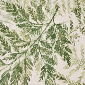 May include: A white fabric with a green fern pattern. The ferns are printed in shades of green and are arranged in a repeating pattern.