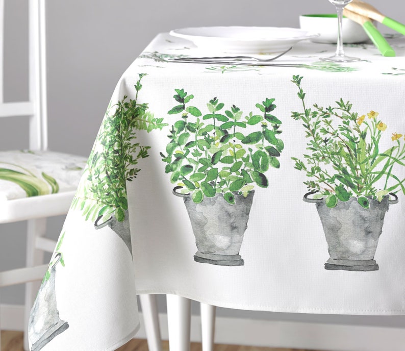Puede incluir: Mantel blanco con estampado bot&aacute;nico verde y blanco con tres plantas en maceta. Las plantas est&aacute;n pintadas en estilo acuarela e incluyen helechos, hierbas y flores.