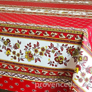 May include: A rectangular tablecloth featuring a vibrant red background with a repeating small-scale pattern. It is accented by wide horizontal bands of white fabric decorated with detailed floral motifs in yellow, red, and dark brown tones.