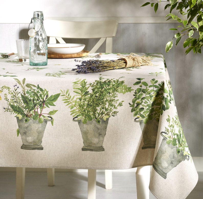 May include: A beige tablecloth with a green and white herb print. The tablecloth features a repeating pattern of potted herbs in a watercolour style.
